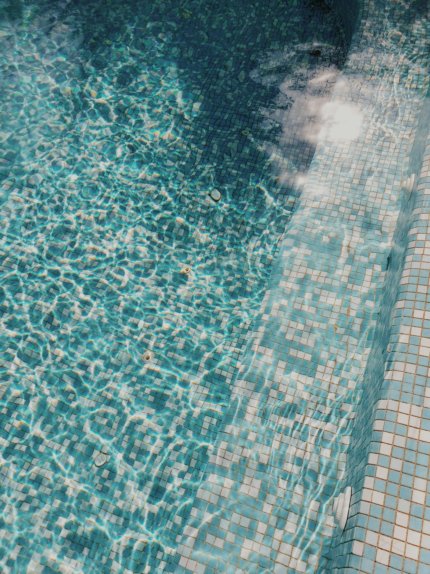 Close-up of a pool with mosaic tiles around the edge
